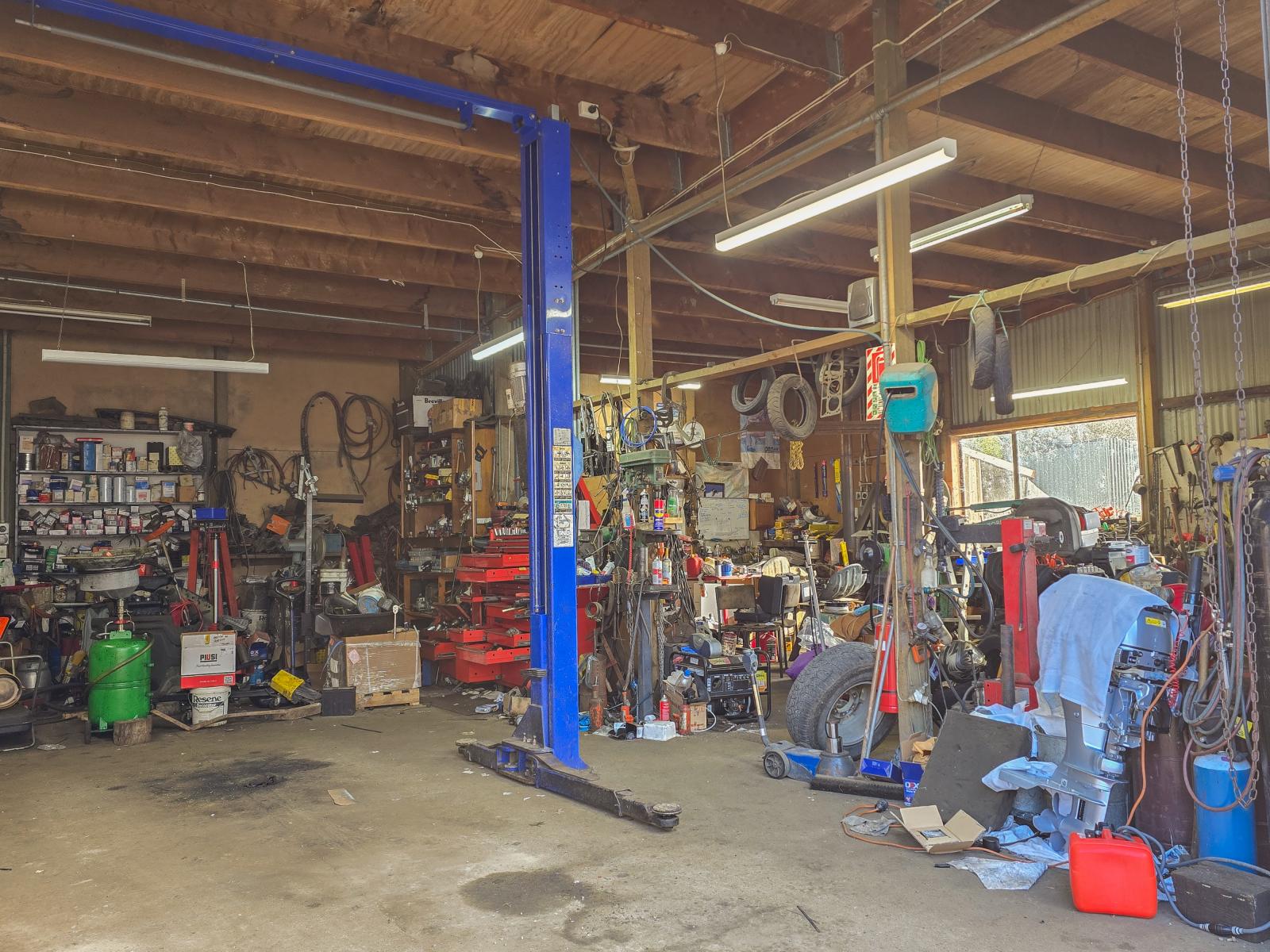 Inside the mechanical workshop at 14 Ayr Street with vehicle hoist and equipment